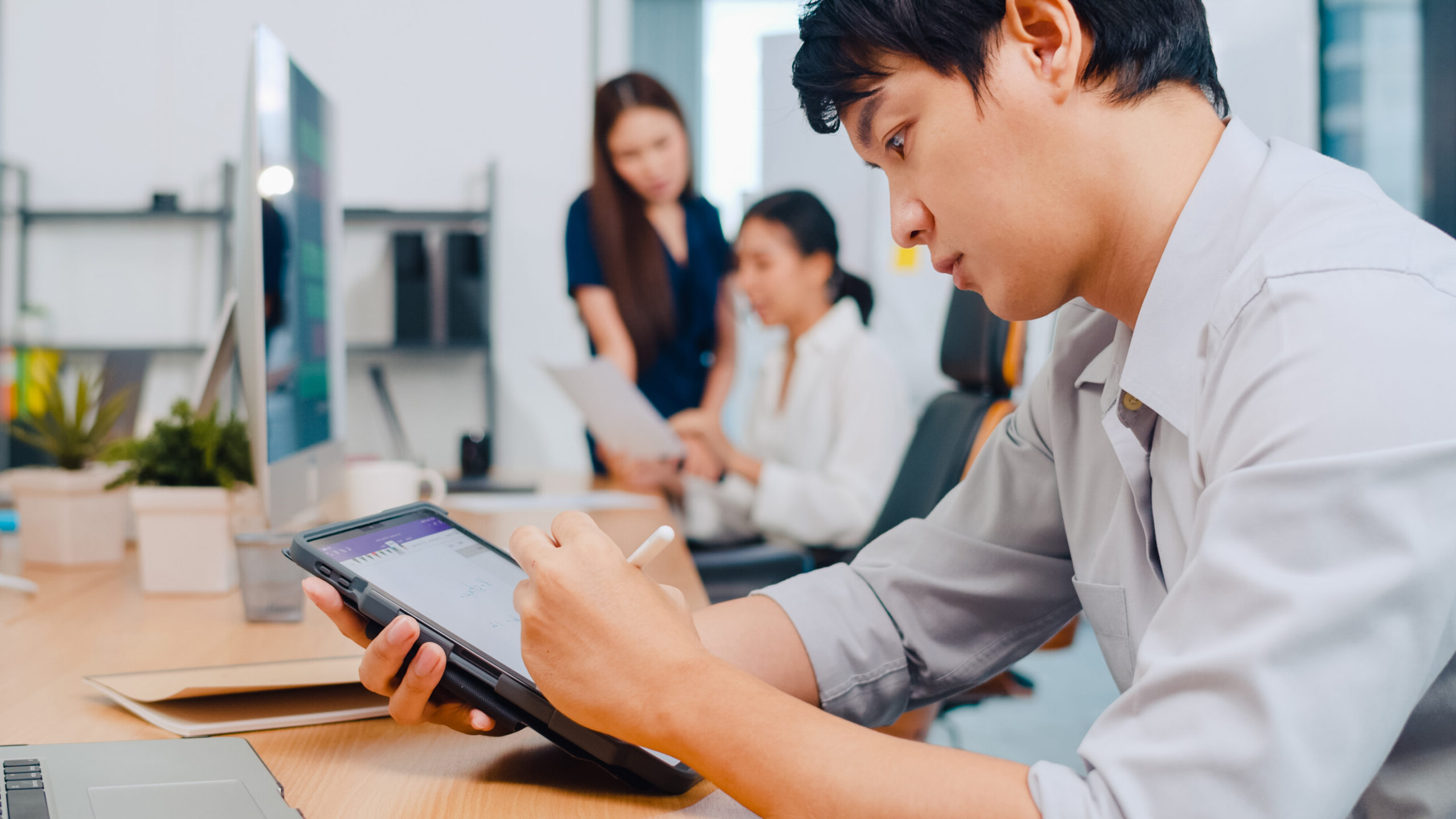 Successful executive Asia young businessman smart casual wear drawing, writing and using pen with digital tablet computer thinking of inspiration search ideas working process in modern office.